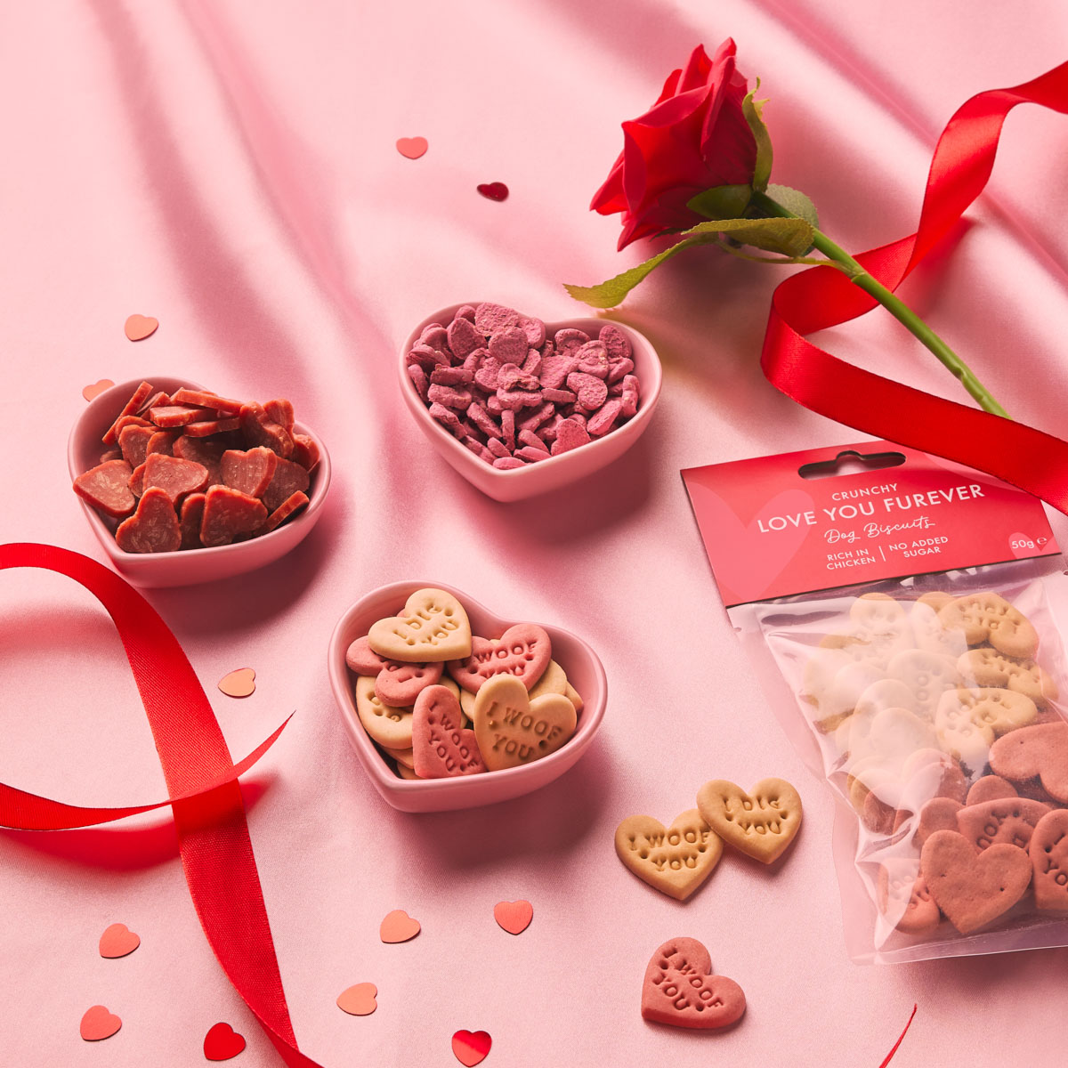 Seasonal pet treat photography – Valentine’s campaign Studio product photography of Valentine’s themed pet treats on a pink background for a commercial campaign
