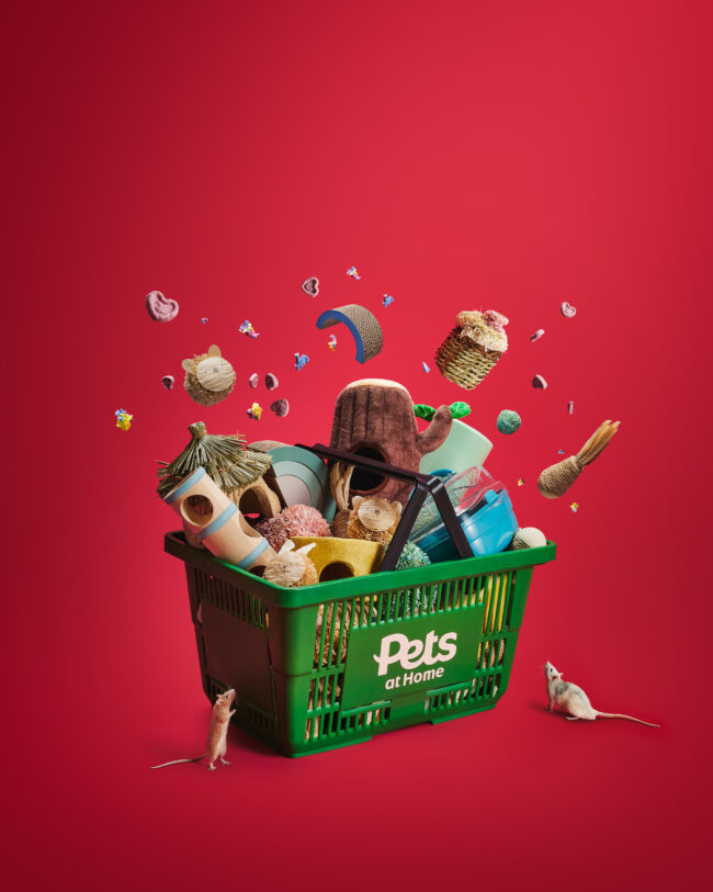 Creative studio product photography showing pet toys and accessories exploding from a shopping crate for a commercial pet brand campaign including rats