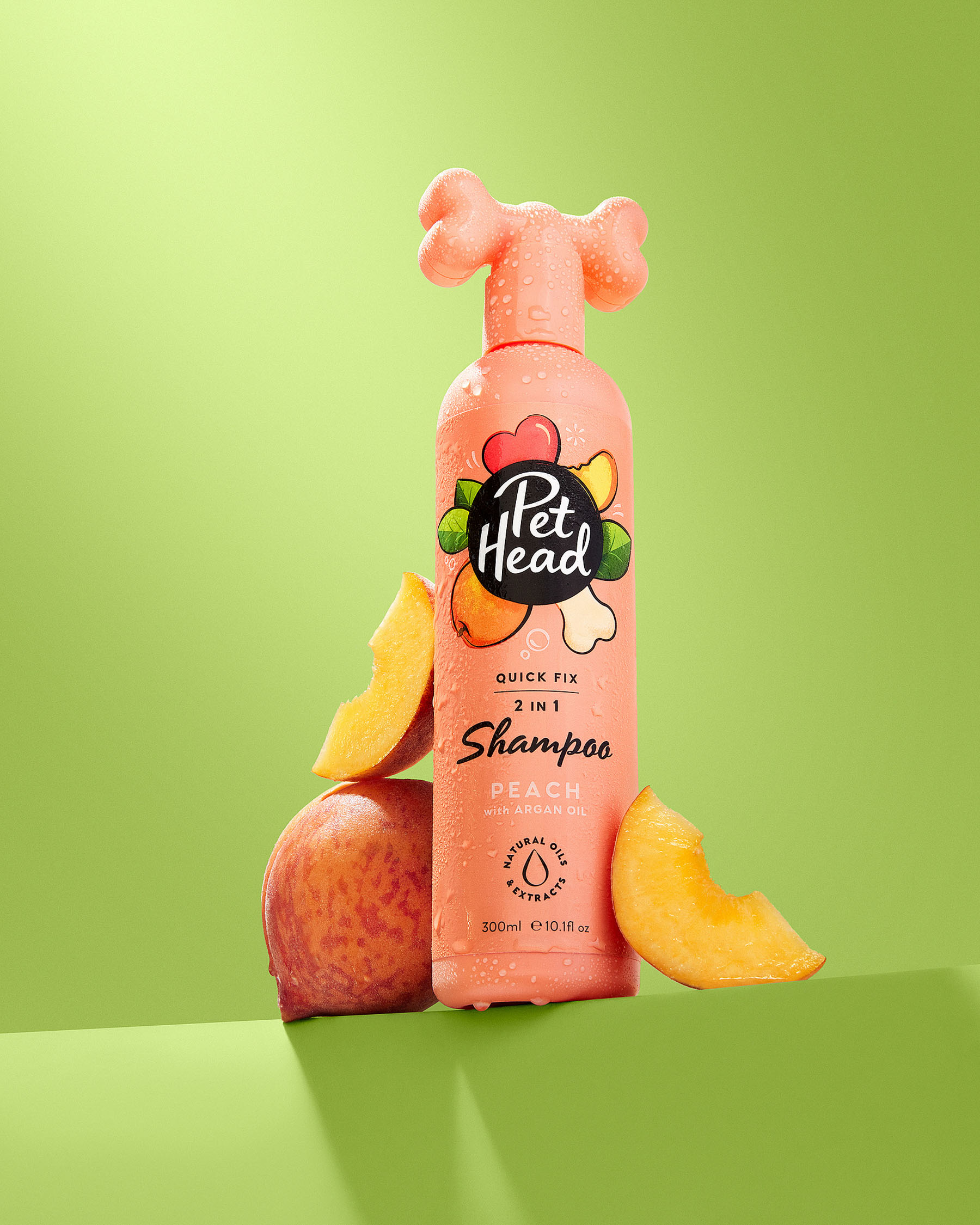 Studio product photography of a pet shampoo bottle with fruit props for a commercial pet grooming brand pet head