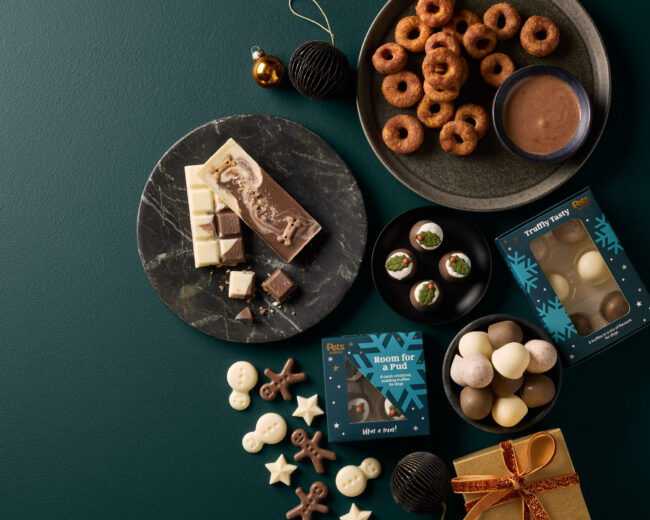Studio flat lay photography of pet treats and snacks arranged on a dark background for a commercial pet food campaign