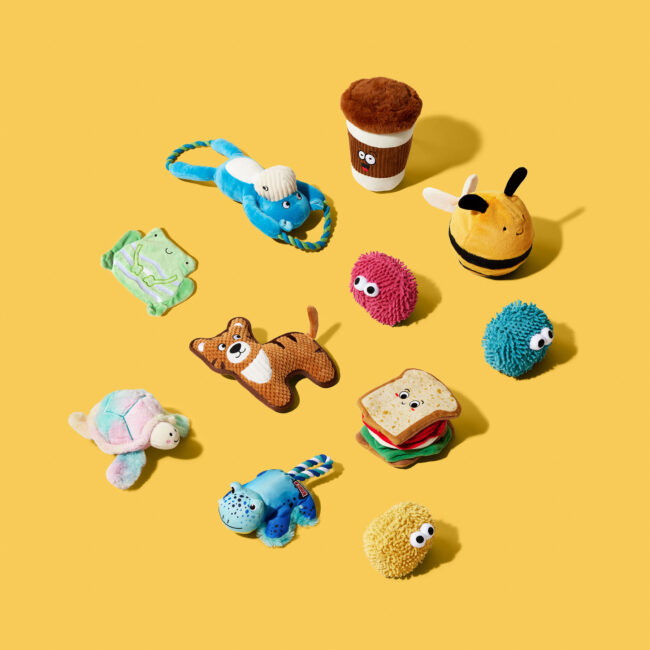 Studio flat lay photography of novelty pet toys on a yellow background for a commercial pet brand campaign