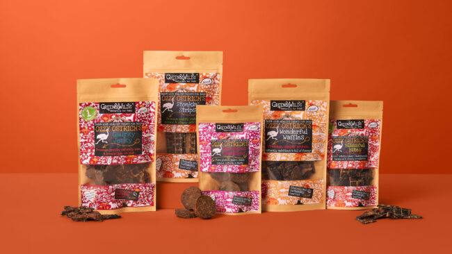 Studio product photography of multiple pet treat packages arranged together for a commercial pet food campaign green & wilds